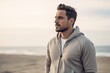 © Robert MEYNER - Handsome young man in sportswear looking away while standing on beach