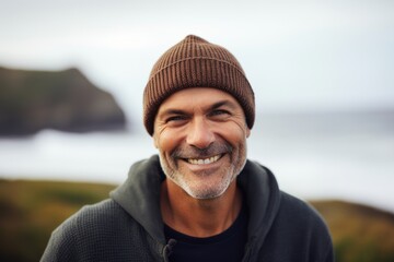 Sticker - Portrait of smiling senior man in beanie and sweater on the beach