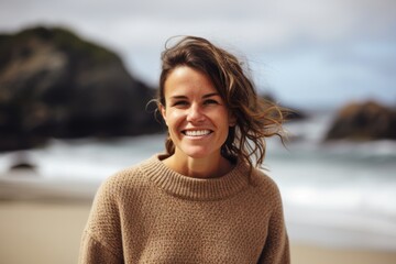 Poster - Portrait Of Smiling Young Woman Wearing Sweater On Beach