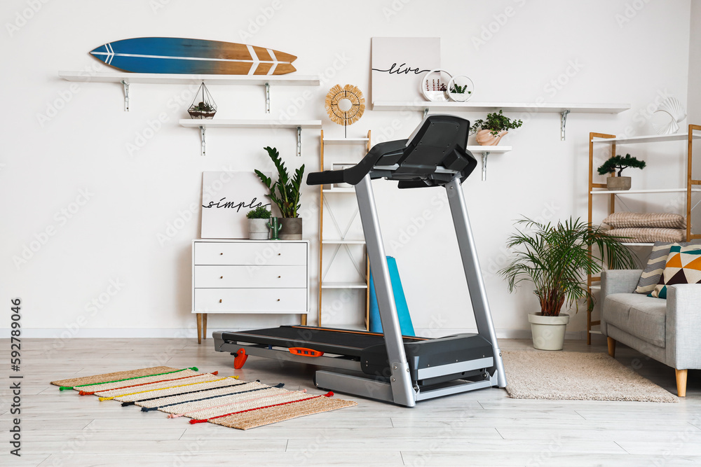 Modern treadmill in interior of living room