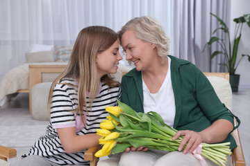 Sticker - Young daughter congratulating her mom with flowers at home. Happy Mother's Day