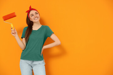 Canvas Print - Happy designer with roller near freshly painted orange wall, space for text