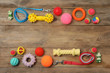 Wall Mural - Flat lay composition with dog leashes and toys on wooden background, space for text