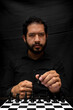 © Narayan - latin man with beard playing chess making decisions, chess concept