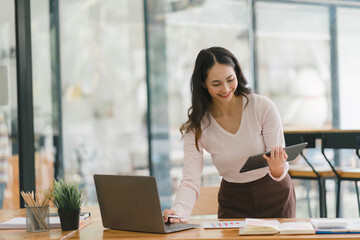 Beautiful asian businesswoman using digital tablet at the desk in modern office.