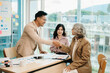 © Nuttapong punna - Business people shaking hands during a meeting. Three happy mature business women