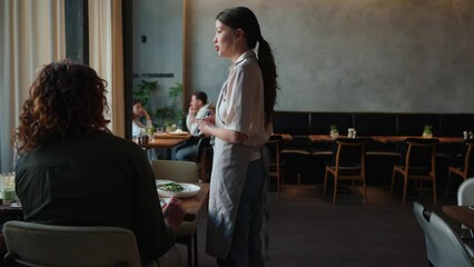 Poster - Serious waitress talks about food to friends celebrating birthday in cafe. Party concept