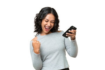 young argentinian woman over isolated background with phone in victory position