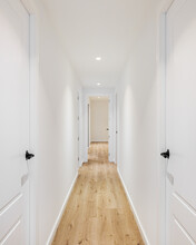 Long Narrow Straight Corridor With Doors On The Left And Right In A Mini Hotel After Renovation. Concept Of A Cozy Hotel And Rooms For Vacation Or Business Trip. Copyspace