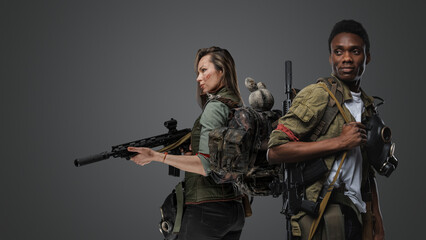 Wall Mural - Shot of black man and white woman with rifles isolated on grey background.