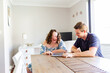 © Austockphoto - Happy young person using tablet device with disability worker at dining table