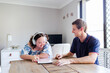 © Austockphoto - Teen wearing headphones talking with adult disability support worker in home office using tablet