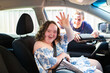 © Austockphoto - Happy young female person with down syndrome in car passenger seat waving goodbye