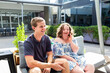 © Austockphoto - Teenager talking with young adult disability worker outside at café sitting on lounge together