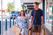 © Austockphoto - Man providing support to go shopping in town for person with a disability walking and talking