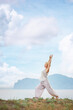 © luengo_ua - Senior woman doing yoga exercises with mountain and sky on the background