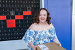 © Austockphoto - Happy young person with a disability holding brown box parcel near post office