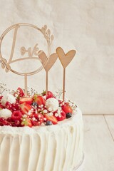 Sticker - Vertical shot of delicious white wedding cake with berries on a white background