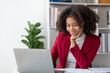 © kamiphotos - A young American woman is a start-up businesswoman, she sits in the office, managing and running a business from a young generation. Startup business management concept.