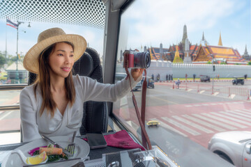 asian traveller woman take a lunch on the restaurant bus between city tour by bus