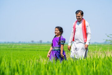 Wall Mural - Happy indian playful kid with villager farming father at farmland - concept of freedom, rural India and caring father