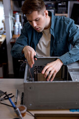 Wall Mural - Repairs and diagnostics breakdowns of laptop in professional service center. caucasian professional electronic master sit behind table, using tools, in workshop. computers repair concept