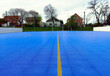 outdoor small soccer court with blue vinyl sport floor. interlocking tiles. modern recreational and track flooring. yellow paint line field divider. sport, recreation and active lifestyle concept 