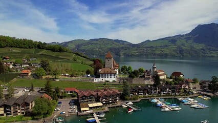 Wall Mural - Switzerland travel. scenic lake Thun and the Spiez village aerial drone footage with medieval castle and old town in the alps in Canton Bern 