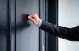 Fototapeta Panele - Close up of young man knocking on the door