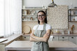 © Liubomir - Portrait of a young blogger woman standing at home in the kitchen in an apron and looking at the camera. Blogs about home economics and cooking.
