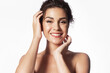 © deniskomarov - Happy satisfied young woman with perfect healthy glowing skin touching face, beautiful girl looking at camera on white studio background. Skincare, natural beauty, face care concept.