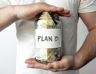 Man holding glass jar with with money inside with word Plan B