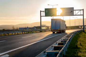 Wall Mural - Rear angle view of delivery truck run on the road with sunset cityscape,fast delivery,cargo logistic and freight shipping concept