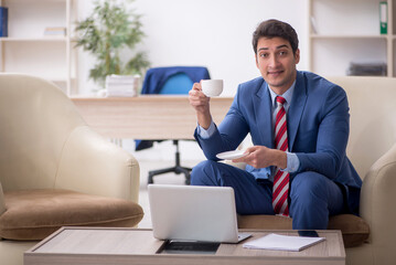 Young male employee sitting in the office