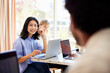 © Cavan Images - Happy female professional sitting with laptop at table in cafe