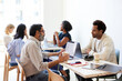 © Cavan Images - Male entrepreneurs discussing during meeting in cafe