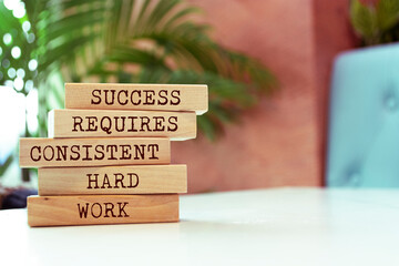 Wall Mural - Wooden blocks with words 'Success requires consistent hard work'. Motivation concept