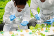 © Nuttapong punna - Researcher in white uniform are checking with ph strips in hydroponic farm and pH level scale graphic, science laboratory greenhouse concept.