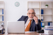 © Elnur - Old male employee working in the office
