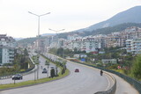 Fototapeta Las - View of the highway, houses and mountains in Alanya, orange groves. Evening time, Türkiye, April 2023.