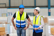 © feeling lucky - Architect or engineering men and worker standing and checking large warehouse with clipboard. Multiethnic two business manager controlling work at warehouse industry building.