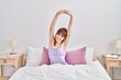© Krakenimages.com - Young woman wearing nightgown stretching arms at bedroom
