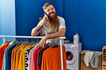 Canvas Print - Young redhead man smiling confident talking on the smartphone at laundry room