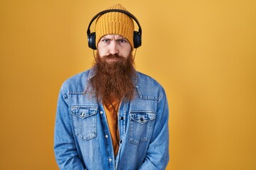 Canvas Print - Caucasian man with long beard listening to music using headphones skeptic and nervous, frowning upset because of problem. negative person.