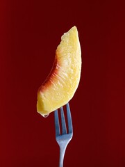 Poster - Closeup of a peach slice on a fork in a maroon background