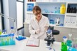 © Krakenimages.com - Young caucasian woman wearing scientist uniform    holding test tube at laboratory