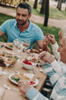 © gstockstudio - Family holding hands while praying before dinner outdoors together