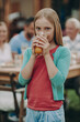 © gstockstudio - Little girl enjoying fresh juice while spending time with her family outdoors