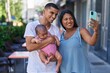 © Krakenimages.com - Hispanic family hugging each other making selfie by smartphone at street