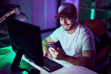 Canvas Print - Young hispanic man streamer using computer and smarpthone at gamin room